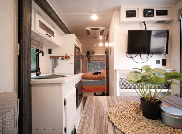 Looking down the R-Pod interior — kitchen on the left, bed at the rear, lounge and TV on the right